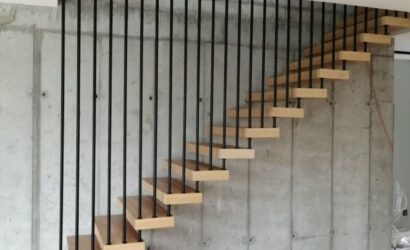 Drewniane schody wewnętrzne z metalowymi balustradami