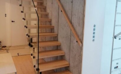 Drewniane schody wewnętrzne ze szklanymi balustradami