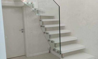 Drewniane schody wewnętrzne ze szklanymi balustradami