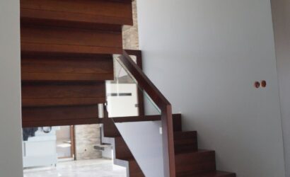 Drewniane schody wewnętrzne ze szklanymi balustradami