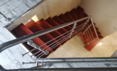 Schody dywanowe ze metalowymi balustradami