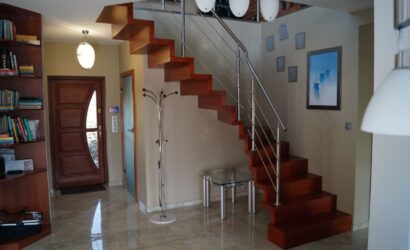 Drewniane schody wewnętrzne z metalowymi balustradami