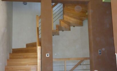 Schody dywanowe ze drewnianymi balustradami