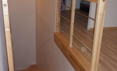 Schody dywanowe ze drewnianymi balustradami