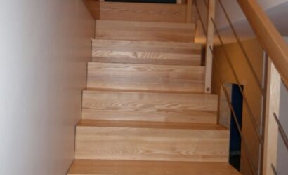 Schody dywanowe ze drewnianymi balustradami