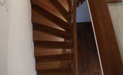 Schody dywanowe ze drewnianymi balustradami