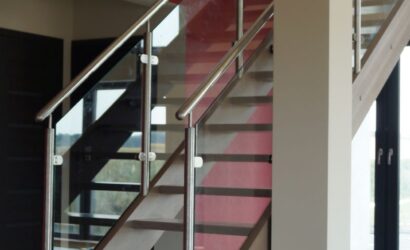 Drewniane schody wewnętrzne ze szklanymi balustradami