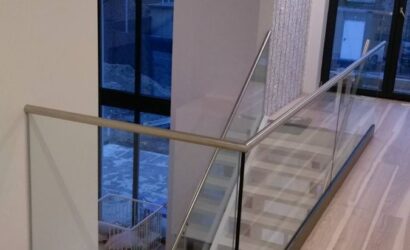 Schody policzkowe ze szklanymi balustradami