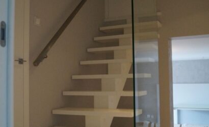 Drewniane schody wewnętrzne ze szklanymi balustradami