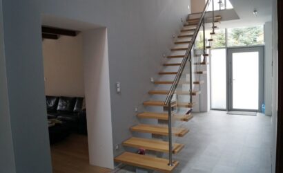Drewniane schody wewnętrzne ze szklanymi balustradami