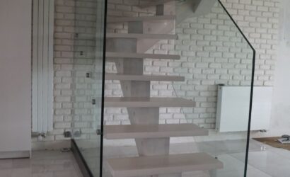 Drewniane schody wewnętrzne ze szklanymi balustradami