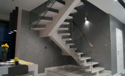 Drewniane schody wewnętrzne ze szklanymi balustradami